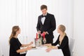 Waiter Taking An Order From Female Friends