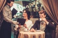 Waiter taking order from stylish wealthy couple Royalty Free Stock Photo