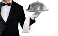 Waiter in tuxedo holding serving tray with metal cloche and napkin