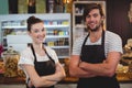 Waiter and waitress standing with arms crossed in cafe Royalty Free Stock Photo