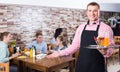 Waiter warmly welcoming guests to cozy family cafe Royalty Free Stock Photo