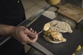 A waiter wearing an apron is preparing a delicious sandwich made of beef and hummus sauce. Small entrepreneur working alone in his Royalty Free Stock Photo