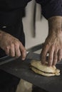 A waiter wearing an apron is preparing a delicious sandwich made of beef and hummus sauce. Small entrepreneur working alone in his Royalty Free Stock Photo