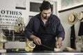 A waiter wearing an apron is preparing a delicious sandwich made of beef and hummus sauce. Small entrepreneur working alone in his Royalty Free Stock Photo