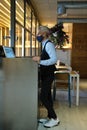 Waiter wearing face mask checking the tables on a counter touch screen. New normal in restaurants.