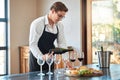 Waiter, wine tasting, and bartender with glass at fine dining vineyard restaurant in countryside. Professional sommelier