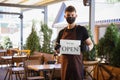 The waiter works in a restaurant in a medical mask, gloves during coronavirus pandemic Royalty Free Stock Photo