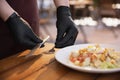 The waiter works in a restaurant in a medical mask, gloves during coronavirus pandemic Royalty Free Stock Photo