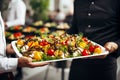 Waiters with colorful vegetable appetizers on plate close-up. Celebration event, party or wedding reception