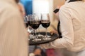 Waiters serve glasses of red wine at a social party