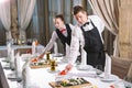 Waiters serving table in the restaurant preparing to receive guests