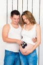 Waiting for the baby. Little baby shoes in the hands of Dad on the tummy of my mother. Royalty Free Stock Photo