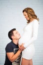 Waiting for the baby. Little baby shoes in the hands of Dad on the tummy of my mother. Royalty Free Stock Photo