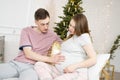 Waiting for Christmas and baby. Young pregnant woman with her husband Royalty Free Stock Photo