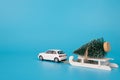 Waiting for Christmas concept. Back rear behind view photo of toy car carrying wooden white mini sledges with toy tree in snow Royalty Free Stock Photo