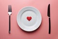 Waiting for a favorite dish in restaurant or cafe. Heart on plate with fork and knife. Lovers meeting at a daily lunch