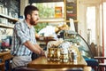 Waiting for the first customer to walk in. a young man working in a coffee shop. Royalty Free Stock Photo