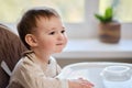 Waiting for food, baby todd is sitting at an empty table. A child in antici Royalty Free Stock Photo