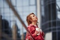 Waiting for the good weather. Adult pretty woman in warm red coat have walk in the city at her weekends time Royalty Free Stock Photo