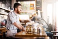 Waiting for his first customer. a young man working in a coffee shop. Royalty Free Stock Photo