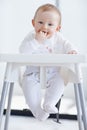 Waiting for mommy to feed me. A cute baby boy in his high chair with his fingers in his mouth. Royalty Free Stock Photo