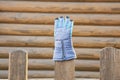 Waiting for spring time concept picture of glove on fence with wooden deck wall background