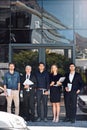 Waiting to welcome you in. Portrait of a team of focused professionals standing in front of a modern office building. Royalty Free Stock Photo