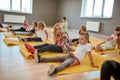 Waiting for trainer. Group of children sitting on yellow yoga mats in the dance studio. Little boys and girls doing
