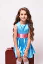 Waiting trip. Large suitcase. Little girl. Blue dress Royalty Free Stock Photo