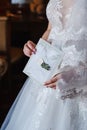 Bride holds an envelope sealed with white sealing wax