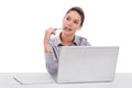 Waiting for work to end. a thoughtful-looking young woman seated in front of a laptop isolated on white.