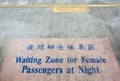 Waiting zone for female passengers at night text sign painted on cement floor with pink background in train platform