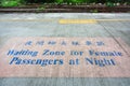 Waiting zone for female passengers at night text sign painted on cement floor with pink background in train platform