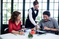 Waitress assisting a couple while selecting menu Royalty Free Stock Photo