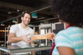 Waitress behind the counter giving loaf to customer Royalty Free Stock Photo