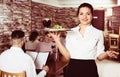 Waitress bringing order for guests in country cafe Royalty Free Stock Photo