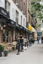 Waitress brings food to the people sitting at the outdoor tables