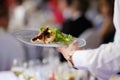 Waitress carrying a plate with meat dish Royalty Free Stock Photo