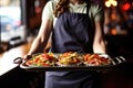 waitress carrying tray of sizzling fajitas at a restaurant