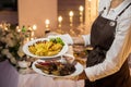 Waitress is carrying two plates with meat dish Royalty Free Stock Photo