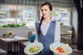 Waitress is carrying two plates with restautant delicious dishes Royalty Free Stock Photo