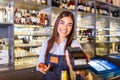 Waitress at cash counter holding an electronic card payment machine. Close up of young woman holding wireless terminal POS at Royalty Free Stock Photo