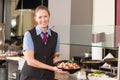 Waitress or catering professional putting food into buffet Royalty Free Stock Photo