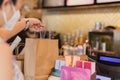 Waitress at counter giving eco friendly paper bag with take away drink in cafe. Royalty Free Stock Photo