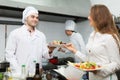 Waitress with food at kitchen Royalty Free Stock Photo