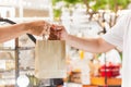 Waitress giving eco friendly paper bag to customer take out.