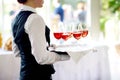 Waitress holding a dish of champagne and wine glasses at festive event