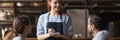 Waitress holding notepad ready take restaurant visitors couple order