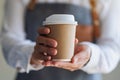 A waitress holding and serving a paper cup of hot coffee Royalty Free Stock Photo