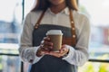 A waitress holding and serving a paper cup of hot coffee Royalty Free Stock Photo